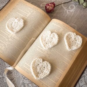 Vintage-inspired crochet hearts displayed on open book for decor or bookmarks