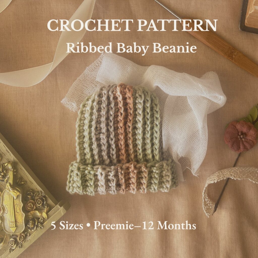 Ribbed baby beanie in sage, clay, and cream tones styled on parchment fabric with crochet hook, vintage book, and lace ribbon — a cozy flat lay highlighting texture and handmade detail.