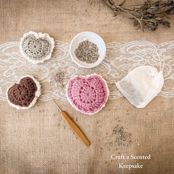 Three crochet puffed heart keepsakes in green, brown, and pink, styled with dried lavender, crochet hook, lace ribbon, and sachet bag on burlap background. Text overlay reads: Craft a Scented Keepsake