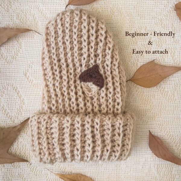 Beige crochet hat with a stitched acorn appliqué — easy to attach beginner crochet embellishment.